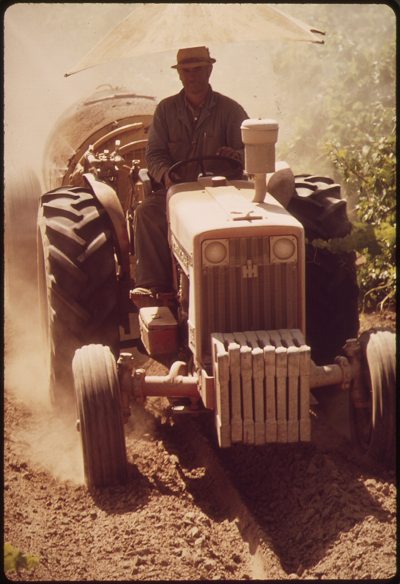 Operador en un tractor durante la pulverización de la plantación