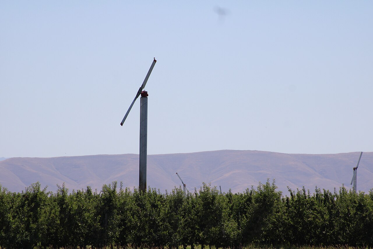 Molino de viento en el plantío que rompe la inversión térmica mediante la mezcla de aire durante la helada radiante